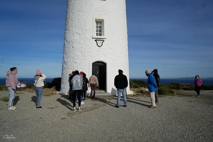 A group of tourists gathered at the base of the Cape Bruny Lighthouse.